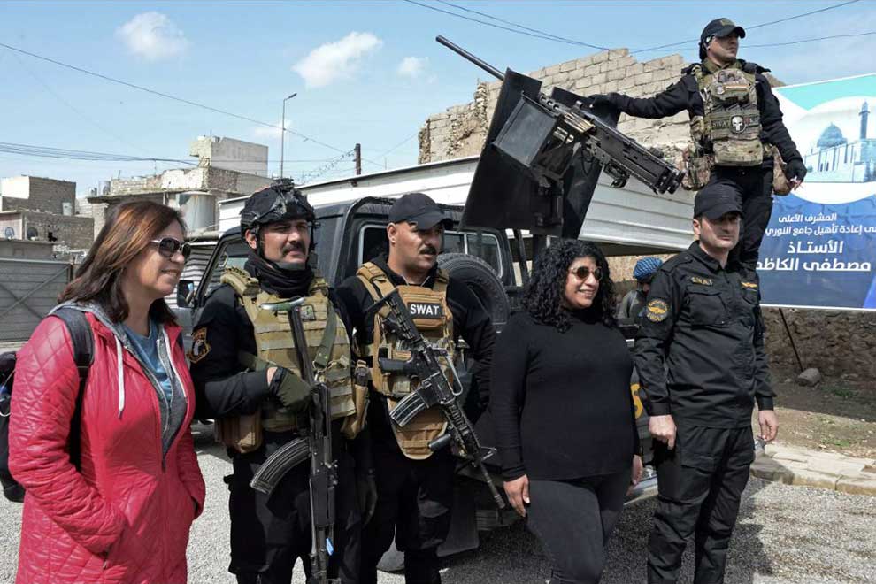 Tourists pose for a picture with Iraqi security forces in the northern city of Mosul on March 12. AFP