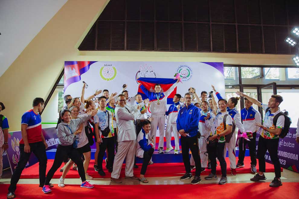 Virak (centre) celebrates with the Cambodian Karate team after winning a gold medal. CAMSOC
