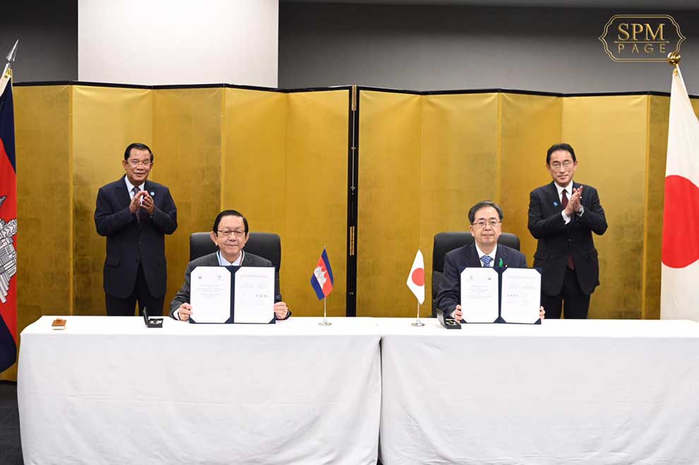 Prime Minister Hun Sen (left) and his Japanese counterpart Fumio Kishida (right) preside over the signing of an MoU by water resources minister Lim Kean Hor (seated left) and Saito Tetsuo of Japan on Saturday. SPM