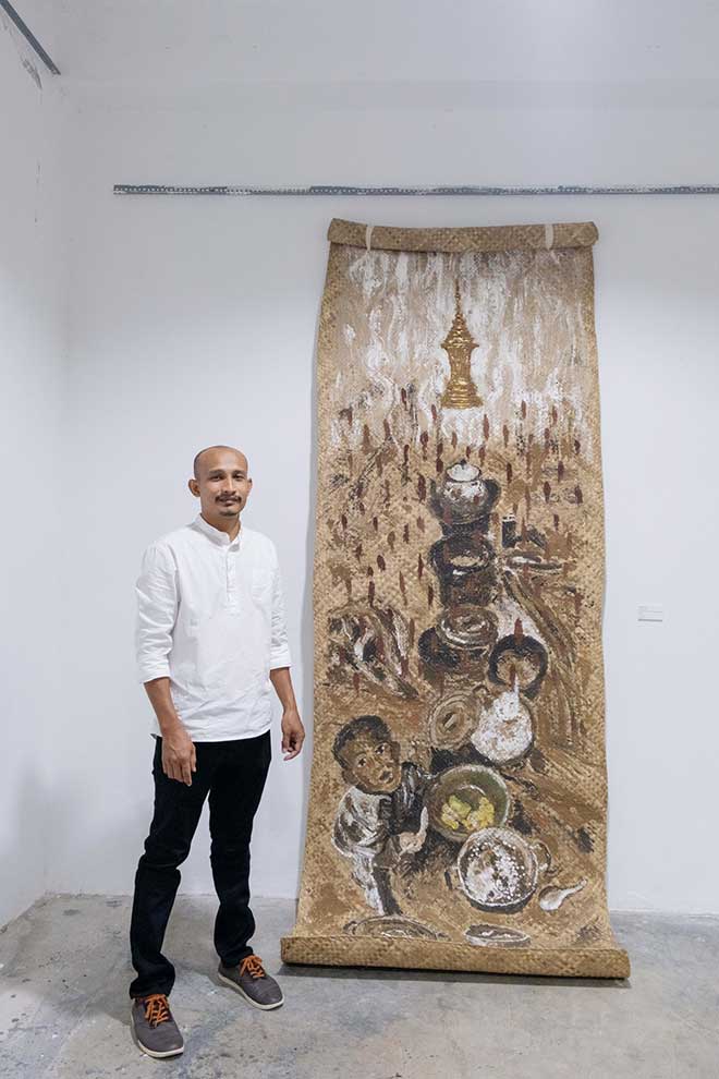 Sereyroth and his painting Wake Up on April 28. He says he hopes his art can help bring about positive change in society. SUPPLIED