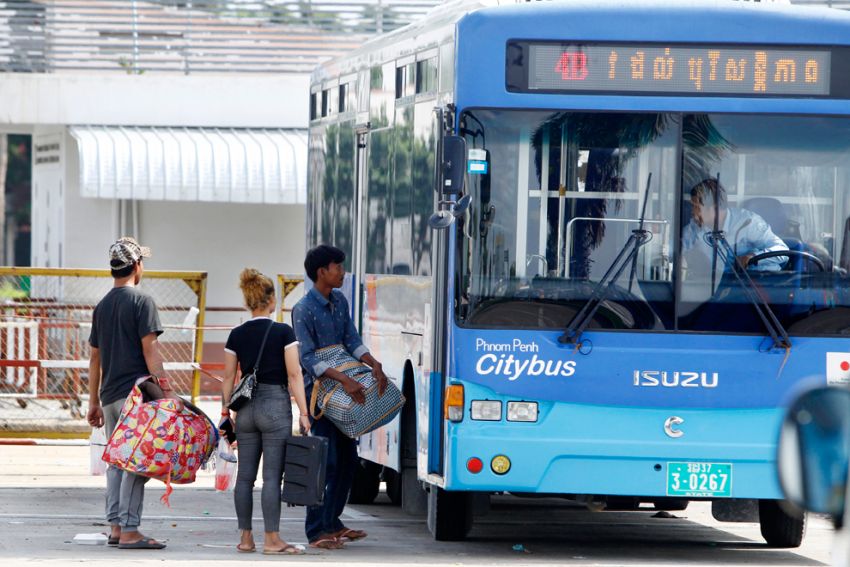 Passengers embark on a public bus in Phnom Penh's Russey Keo district.