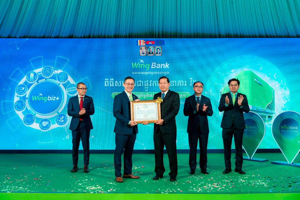 Wing Bank CEO Han Peng Kwang (left) receives certification from the National Bank of Cambodia's HE Rath Sovannorak (right) at the launch event. SUPPLIED