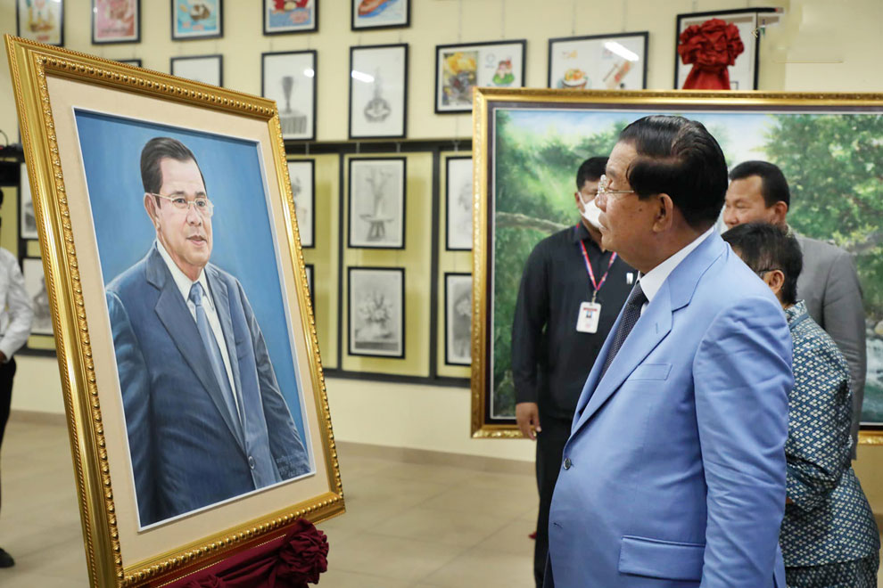 Prime Minister Hun Sen gazes at a portrait of himself painted by Royal University of Fine Arts students, on May 24 during the inauguration of a university building in the capital's Chroy Changvar district. SPM