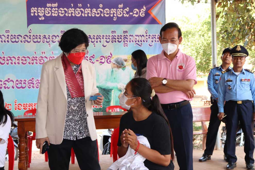 Health ministry spokeswoman Or Vandine (left) talks to people queued up for the Covid jab in Tbong Khmum province in February. MOH