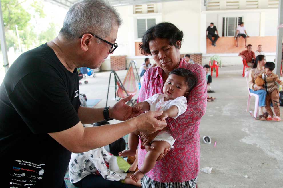 Smile Cambodia executive director Chan Kok Choy with a mother and child at Kampot Provincial Referral Hospital on December 2.