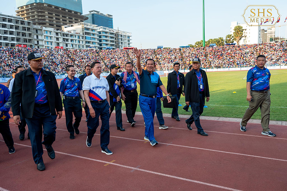 Senate president Hun Sen (centre, in blue), waves to the crowd at the packed National Olympic Stadium. SHS