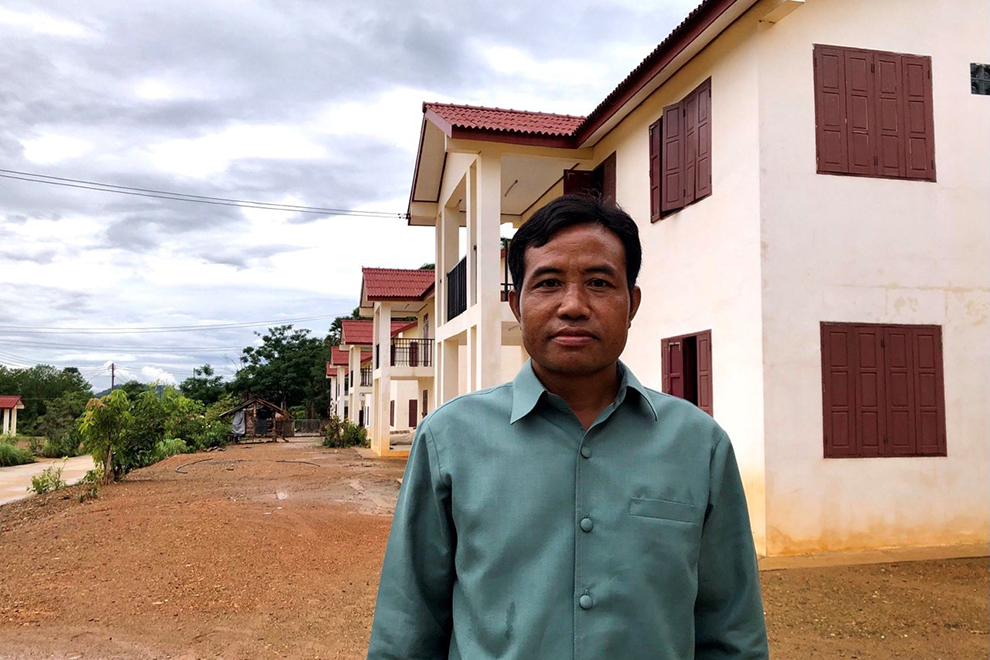 Somphong Somphonpha, chief of Buan Aor village in Luang Prabang province’s Xiang Ngeun district, stands in front of the new homes which were built for villagers who were relocated during construction of the Laos-China Railway. Niem Chheng