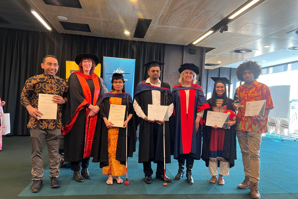 Min Chenda (centre, left) with her fellow graduates and professors at Flinders University in Adelaide, Australia. Supplied