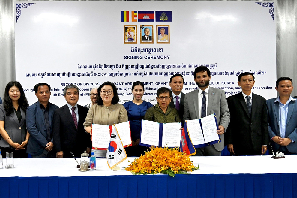 KOICA country director Choi Moon Jung (centre left), culture minister Phoeurng Sackona (centre) and UNESCO representative in Cambodia Alam Sardar Umar (centre right) display the grant documents during a signing ceremony at Tuol Sleng Genocide Museum on August 8. KOICA