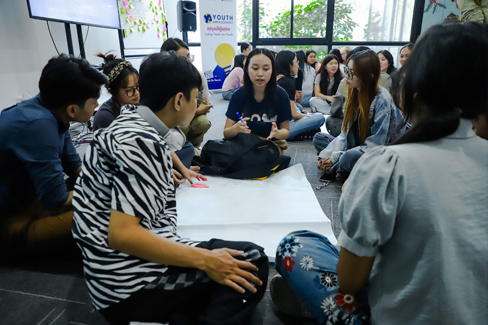 Cheng Sereysothyka, a Youth Light Up Talk volunteer, (black T-shirt, centre) works with other youth volunteers. Supplied