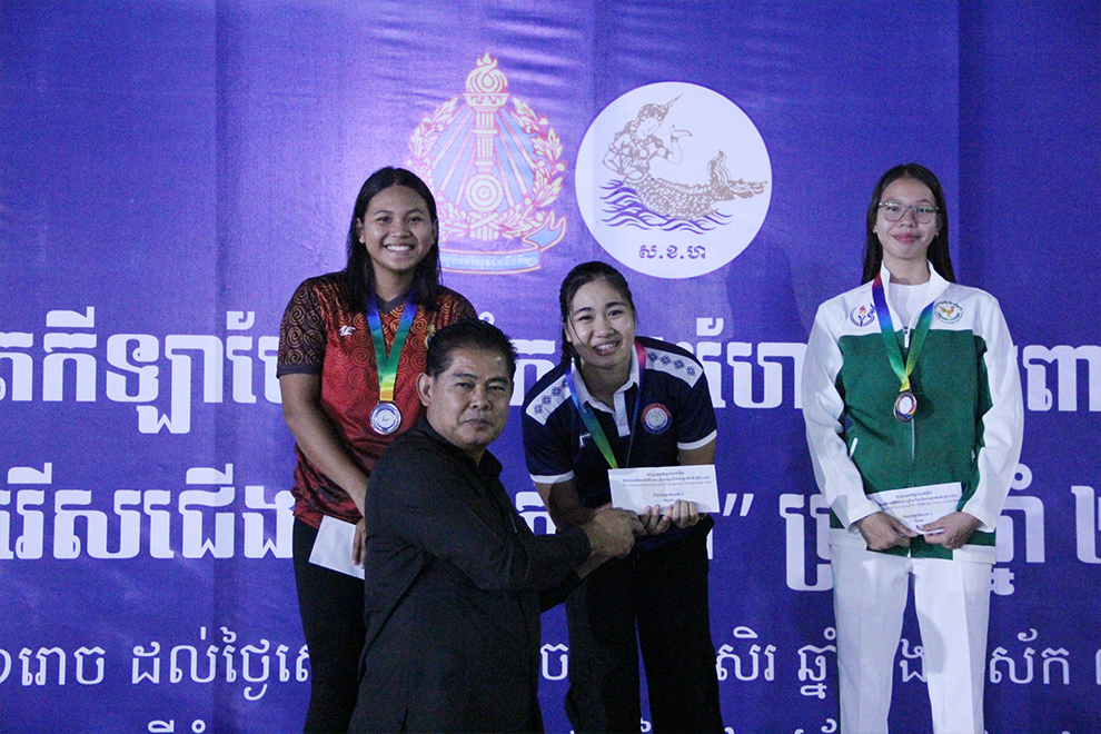 Pon Sok, director-general of the General Department of Sports, presents medals and cash prizes to female athletes who won in the finswimming category at the 2024 National Swimming Championship. Chhorn Norn