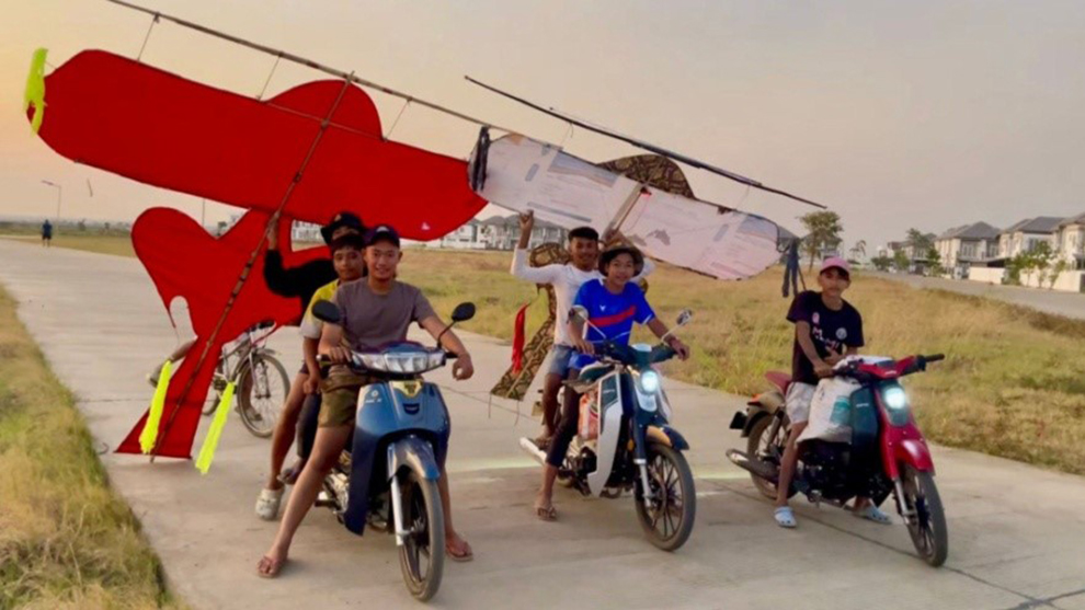 Young people carry their Kleng Ek kites, ready to fly. Supplied