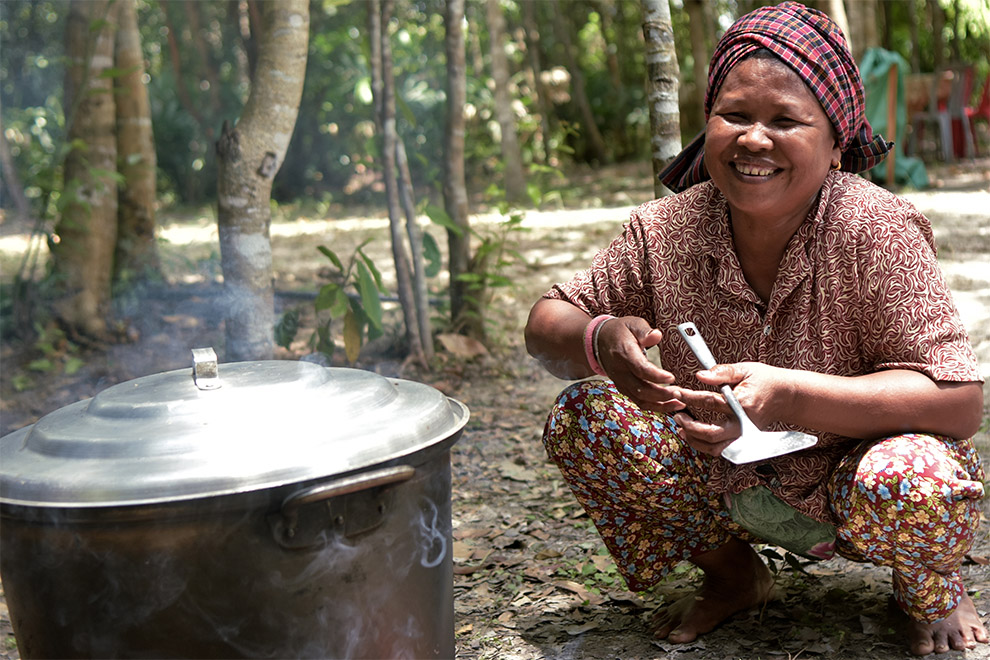 Another smiling Kouy woman prepares a meal with the bounty of the land that sustains them. Supplied