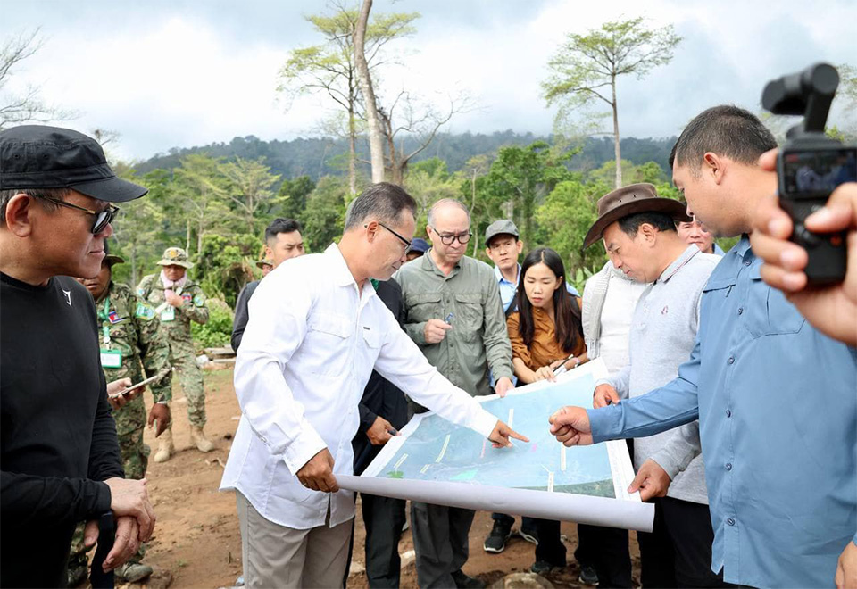 Members of an inter-ministerial working group examine a map of Khnang Phsar as they make plans for