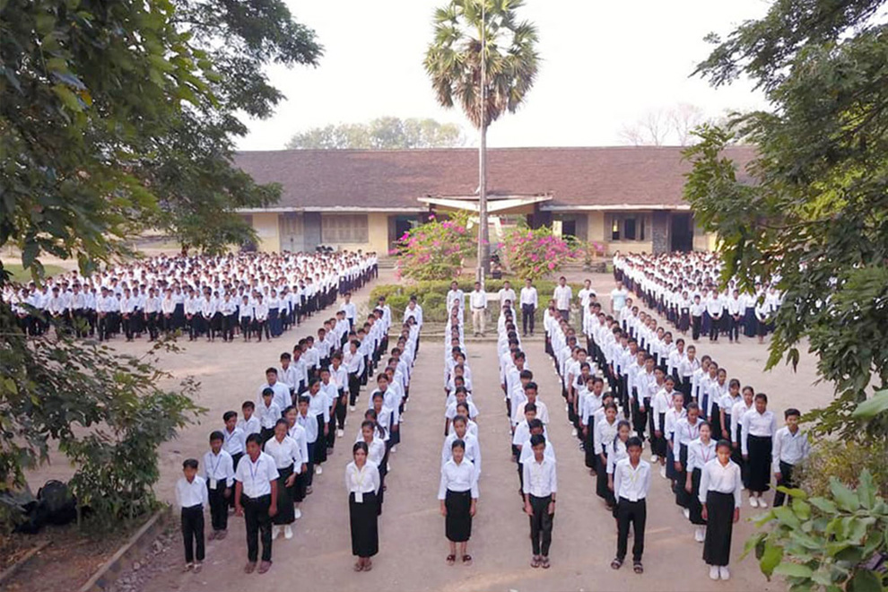 Students of Moung Russey Secondary School in Battambang province assemble outside their new facility to sing the national anthem. Supplied