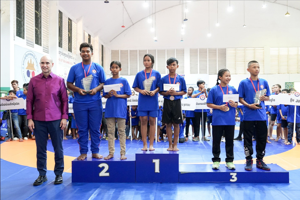 Cambodian Wrestling Federation vice-president Casey Barnett (left) stands alongside some of the tournament medallists. Supplied
