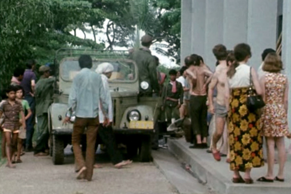 People on the grounds of the French embassy observe Khmer Rouge soldiers (in red kramas) as they enter the compound on April 17, 1975. DC-Cam/The Lon Nol Dossier