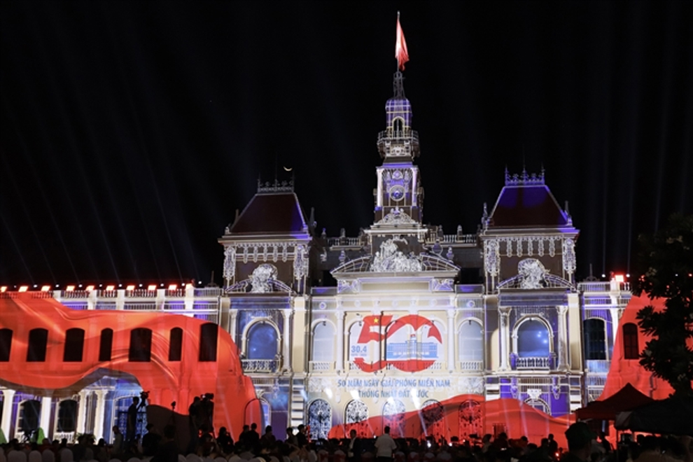 Onlookers enjoy a 3D Mapping projection of the symbol of 50 years of Southern Liberation and National Reunification in the city. PHOTO: VNA/VIET NAM NEWS