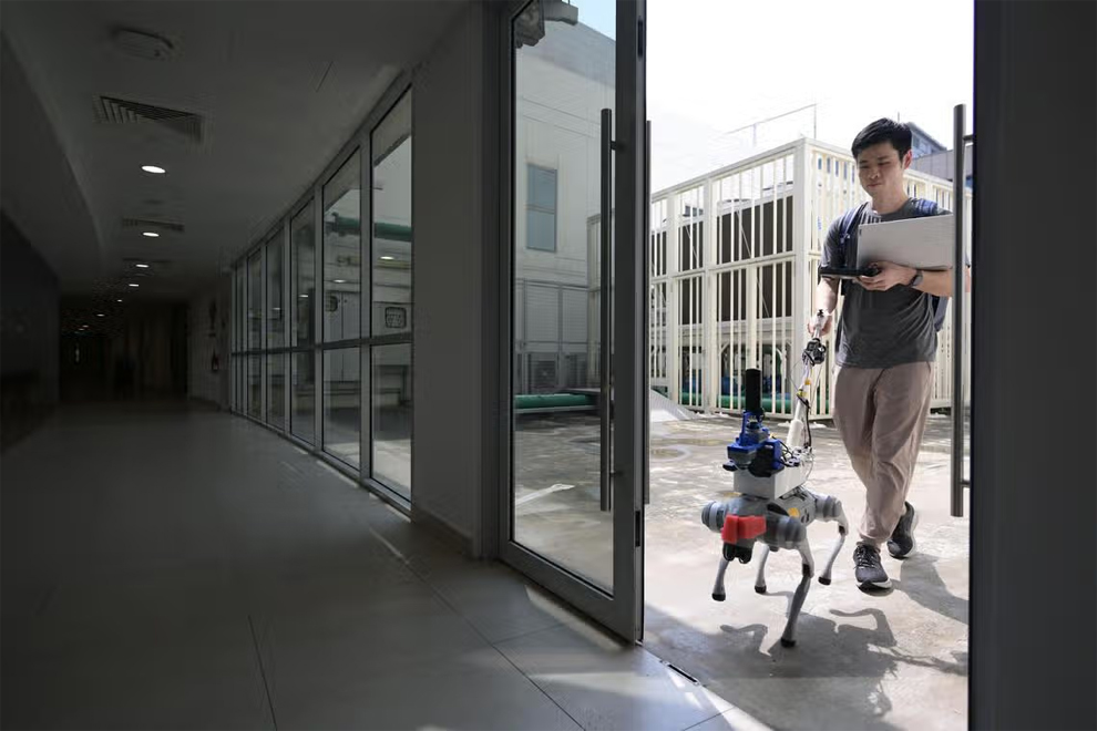 Robotics PhD student Cai Shaojun with a robotic dog that has been programmed to guide visually impaired users. PHOTO: THE STRAITS TIMES