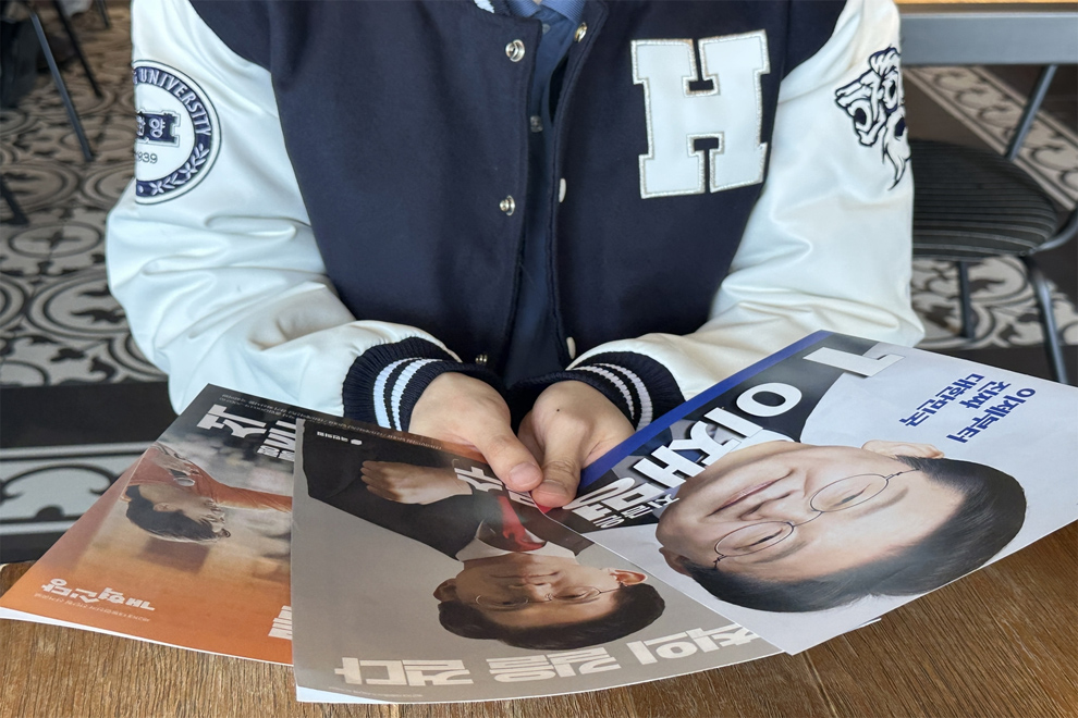 University student Lee June-seong, 25, looks at election pamphlets of the three major candidates — Lee Jae-myung of the Democratic Party of Korea, Kim Moon-soo of the People Power Party and Lee Jun-seok of the New Reform Party — during an interview with The Korea Herald at Hanyang University in Seongdong-gu, eastern Seoul, Tuesday. PHOTO: THE KOREA HERALD