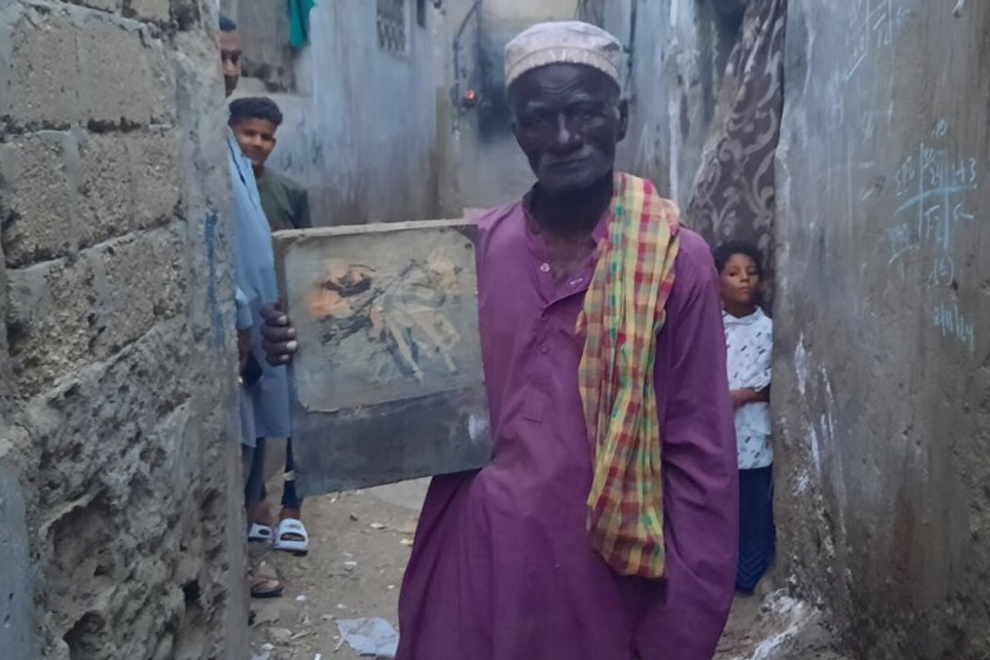 Abdul Hussain Pattak, 62, with a picture of the late Dumper painted by his nephew who Pattak says could ‘capture us, just as we stand here, with his art’. PHOTO: DAWN
