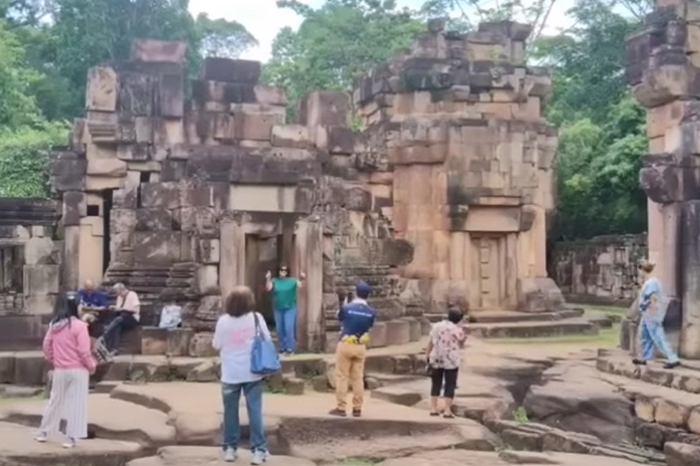 A group of Thai tourists, including a former interior minister and the chair of a political party, take photographs at the temple during their visit. FB