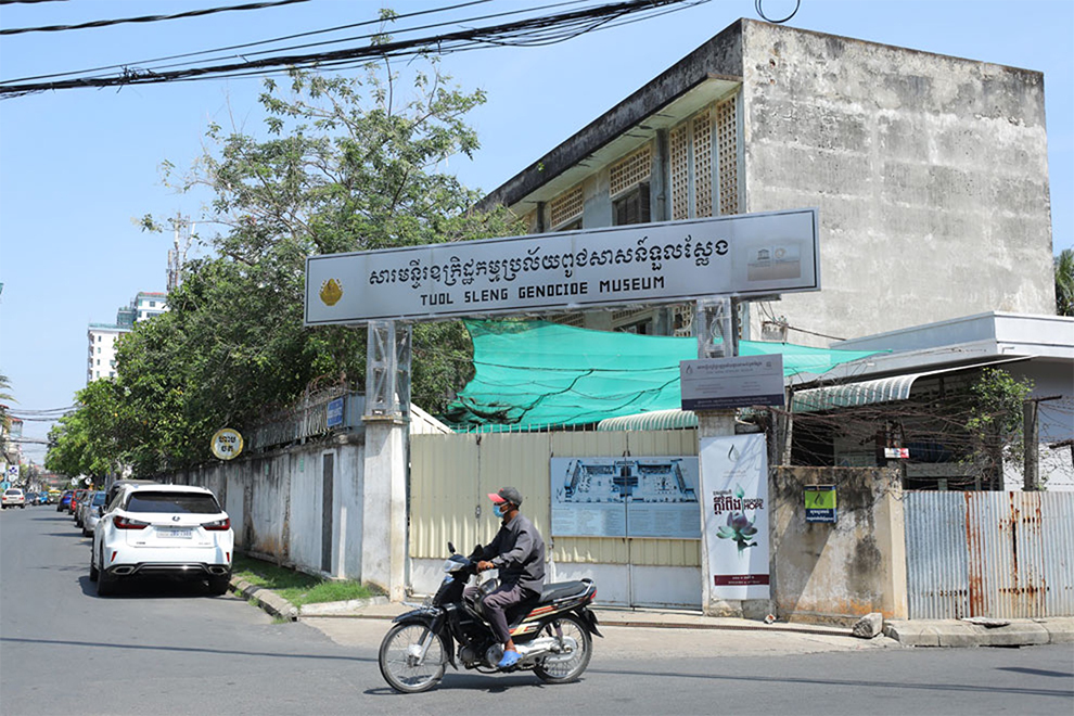 People examine human skulls in a stupa at Choeung Ek. Post Staff