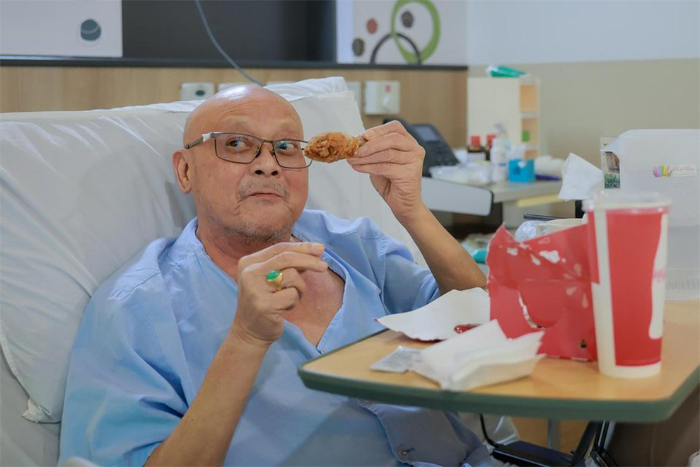 Assisi Hospice patient Yeo Kok Hoong, who has lung and brain cancer, enjoying the fried chicken he requested. PHOTO: THE STRAITS TIMES