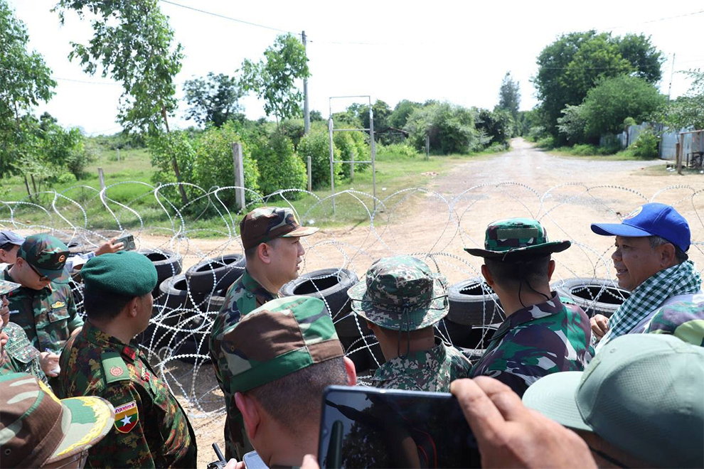 A multinational observer team inspect a barbed wire and tyre barricade built by Thai forces. Supplied