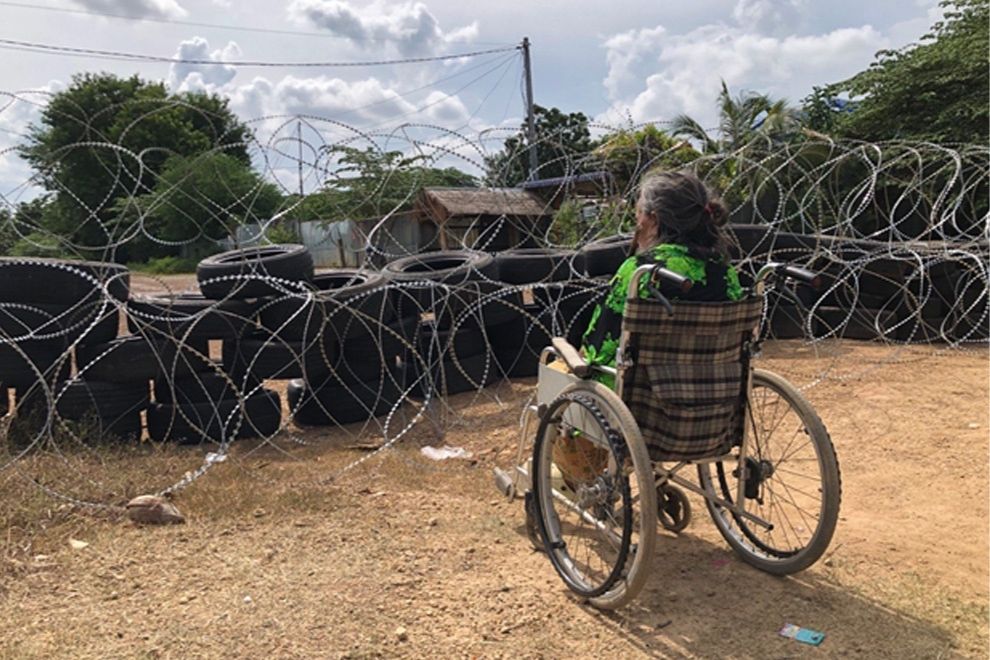 Neang Choeun stares at her home, now denied to her by a makeshift Thai barricade. Niem Chheng
