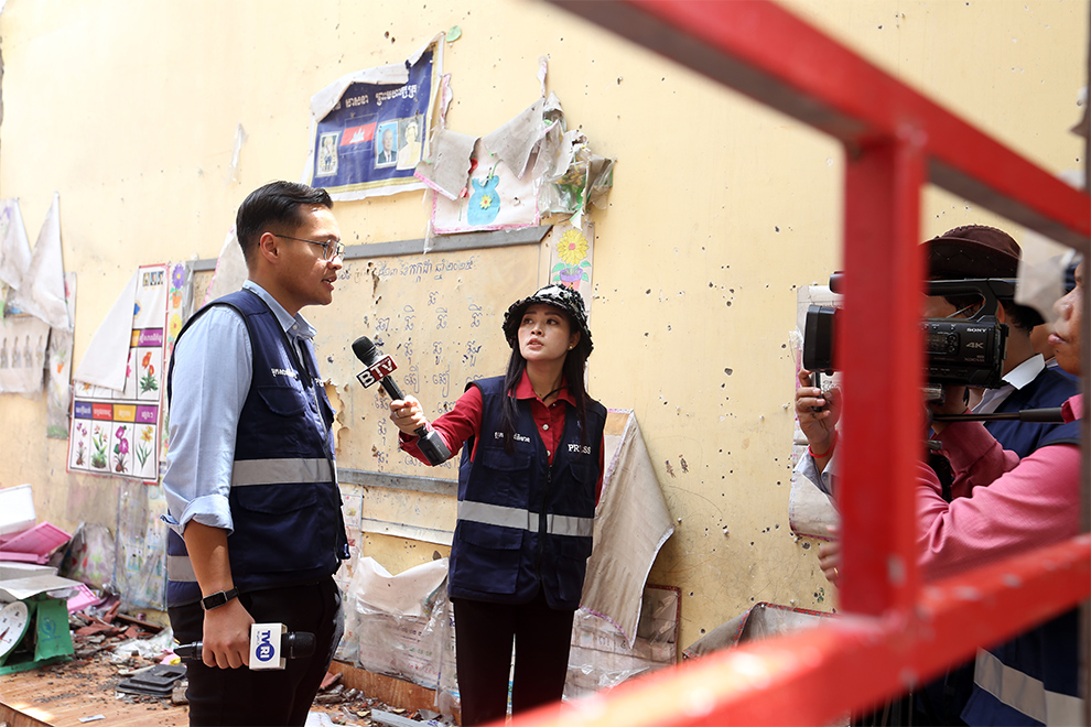 A local reporter interviews an international correspondent at a primary school that was bombed by the Thai air force. Hong Raksmey