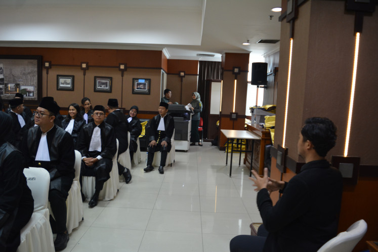 Andi Kasri Unru (second left) observes a sign language interpreter (right, foreground) during a ceremony on June 24, 2025, as a group of lawyers take their oath at the Jakarta High Court in Cempaka Putih, Central Jakarta. PHOTO: CONTRIBUTED/THE JAKARTA POST