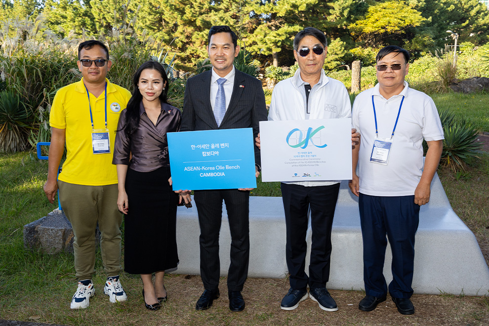 Khuon Phon Rattanak, Cambodian ambassador to South Korea (centre) and his spouse, Kim Jae-shin, secretary -eneral of the ASEAN-Korea Centre and Cambodian journalists pose for a photograph at the Cambodia bench on Jeju Island. Supplied