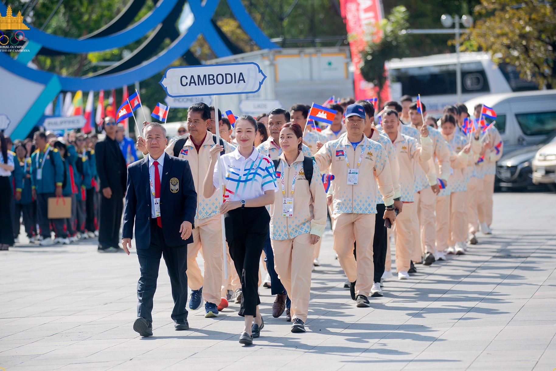 Vath Chamroeun leads the Cambodian delegation during the December 8 flag ceremony. The  NagaWorld-branded uniforms are under investigation by Thai authorities, though Cambodia maintains no sporting regulations were violated. Supplied