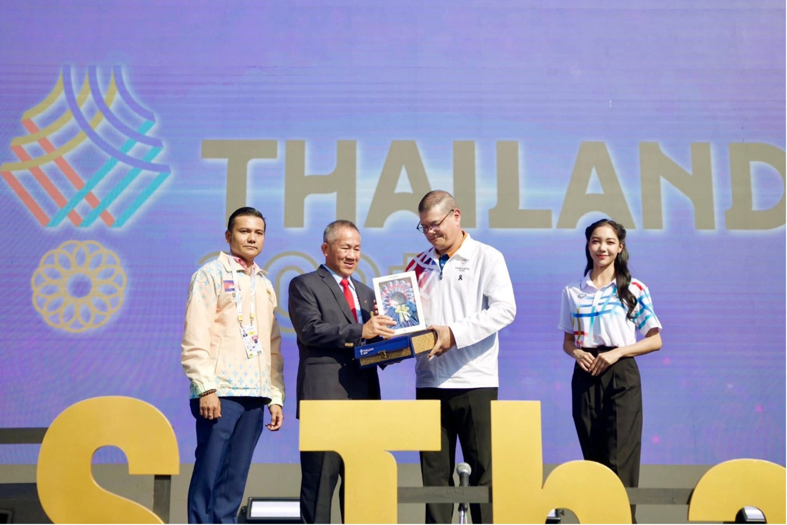 Nhan Sokvisal (left) and Vath Chamroeun receive commemorative souvenirs recognising Cambodia’s participation in the SEA Games flag ceremony on December 8, in Thailand. NOCC