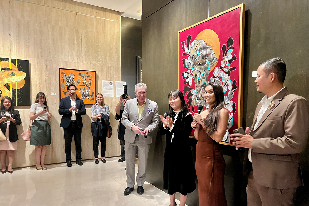 Ouk Vichet, a graduate and professor at the Royal University of Fine Arts (RUFA) poses near his intricate metal lotus artwork. Hong Raksmey