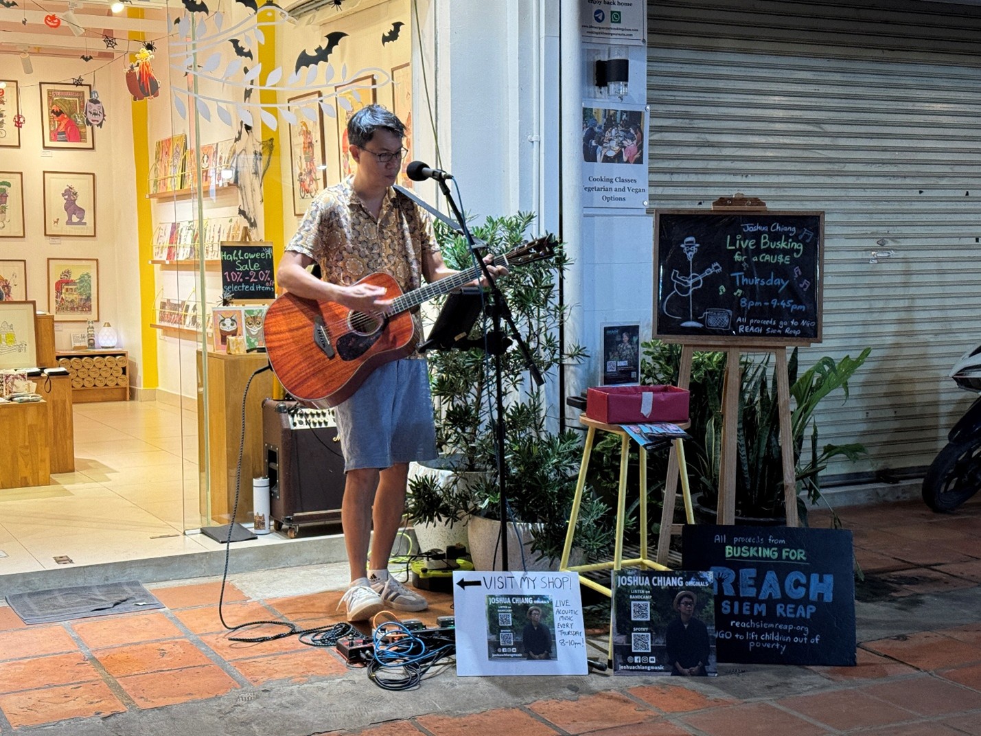 Joshua Chiang busks outside CamCam on one of his regular Thursday evening performances. Proceeds go to REACH Siem Reap, an NGO that supports underprivileged children through English education and school meals. Supplied