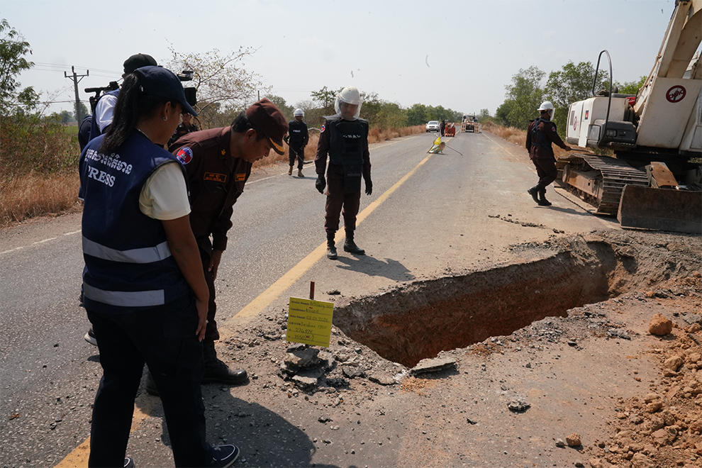 CMAC official Long Wutthiya shows members of the media a 155mm shell that struck National Road 58 and penetrated about 1.5 metres into the ground. Hong Raksmey